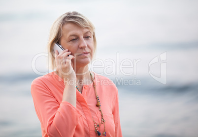 Blond woman having a phone talk outdoor