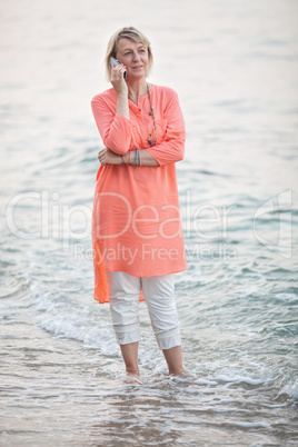 Woman talking on mobile phone at the seaside