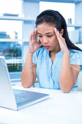 Stressed businesswoman working at her desk