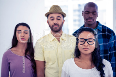 Businesswoman and team with eyes closed