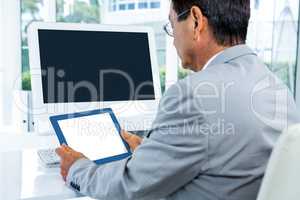 Businessman looking at his tablet