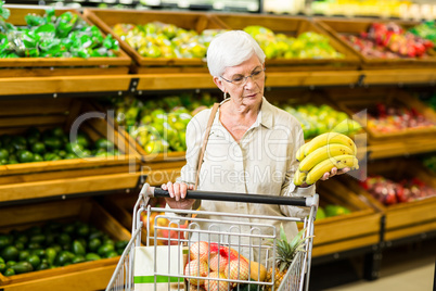 Senior woman putting banana in her trolley