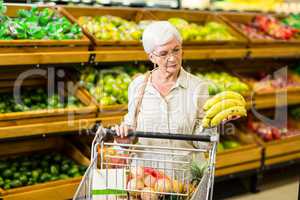 Senior woman putting banana in her trolley