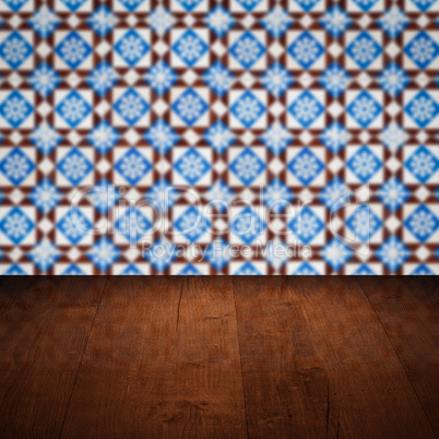 Wood table top and blur vintage ceramic tile pattern wall