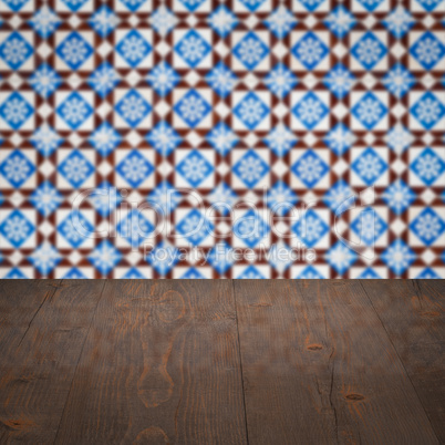 Wood table top and blur vintage ceramic tile pattern wall