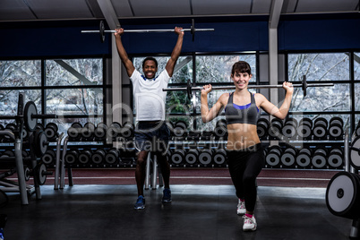 Fit couple exercising with barebell