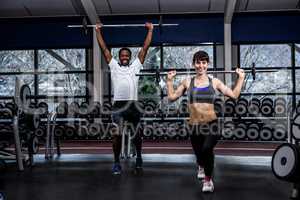 Fit couple exercising with barebell