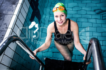 Smiling swimmer woman getting out of the swimming pool