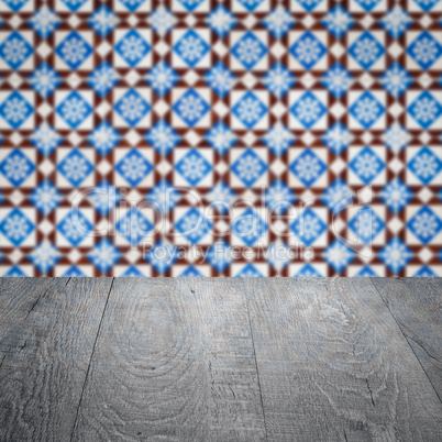 Wood table top and blur vintage ceramic tile pattern wall