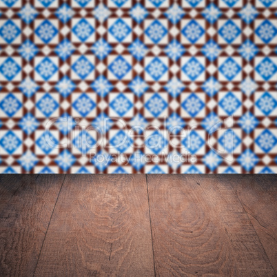 Wood table top and blur vintage ceramic tile pattern wall