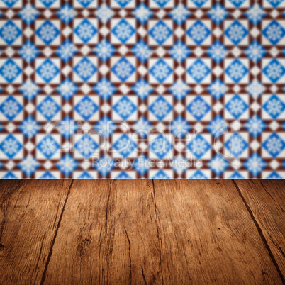 Wood table top and blur vintage ceramic tile pattern wall Wood table top and blur vintage ceramic tile pattern wall