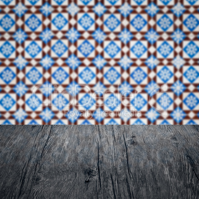 Wood table top and blur vintage ceramic tile pattern wall