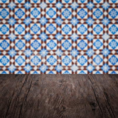 Wood table top and blur vintage ceramic tile pattern wall