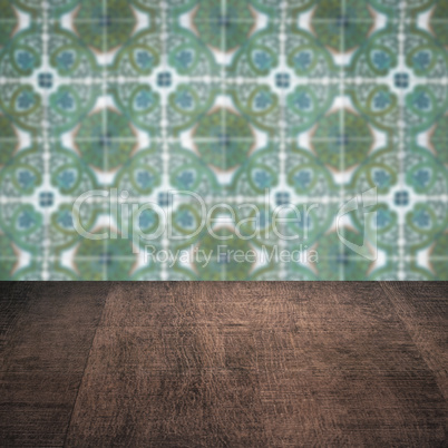 Wood table top and blur vintage ceramic tile pattern wall