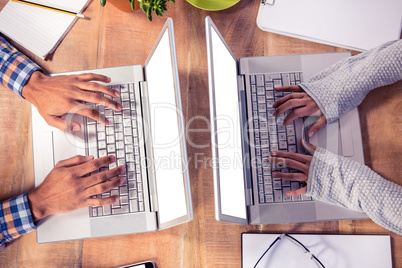 Overhead view of hands typing on laptop keyboard