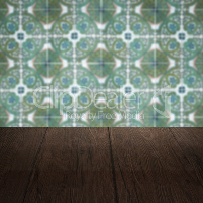 Wood table top and blur vintage ceramic tile pattern wall Wood table top and blur vintage ceramic tile pattern wall