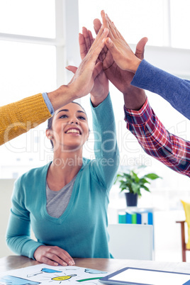 Business woman doing high five with team in creative office