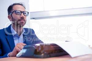 Thoughtful businessman looking away while working on typewriter