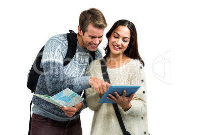 Couple using map and digital tablet while traveling
