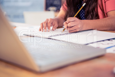 Businesswoman writing in book