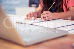 Businesswoman writing in book