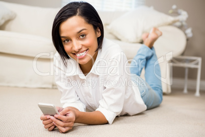 Smiling brunette using smartphone