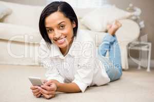 Smiling brunette using smartphone