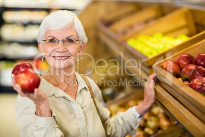 Senior woman picking out a red apple