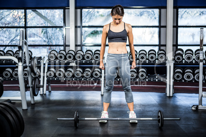 Fit woman preparing herself for barebell exercise