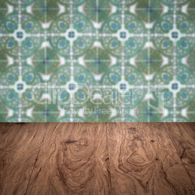 Wood table top and blur vintage ceramic tile pattern wall