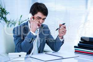 Angry asian businessman on the phone