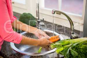 Mid section of woman washing carrots