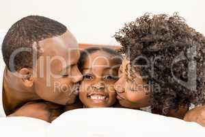 Smiling family lying in bed