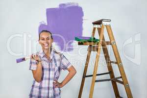 Smiling woman painting a wall