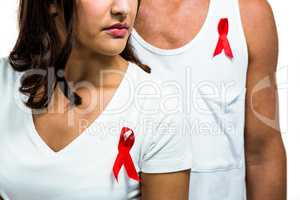 Midsection of man and woman with red ribbon on clothes