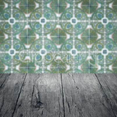 Wood table top and blur vintage ceramic tile pattern wall