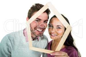 Smiling couple holding house shape