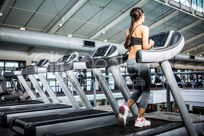 Rear view of woman jogging in treadmill