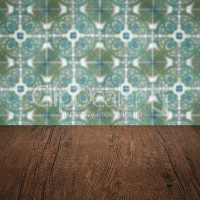 Wood table top and blur vintage ceramic tile pattern wall