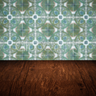 Wood table top and blur vintage ceramic tile pattern wall