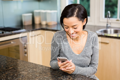 Smiling brunette using smartphone