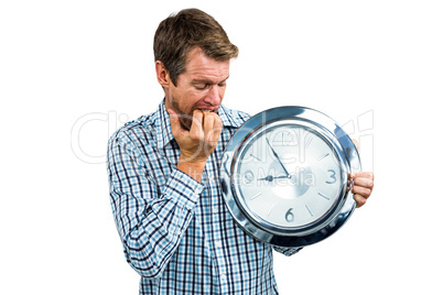 Anxious late man holding a clock