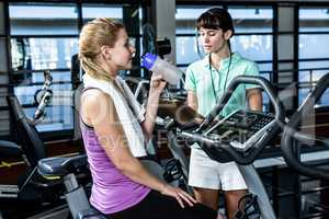 Fit woman doing exercise bike with trainer