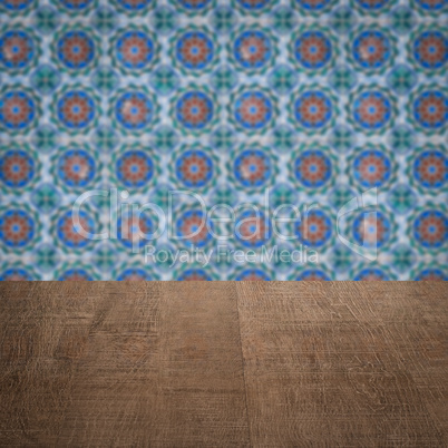 Wood table top and blur vintage ceramic tile pattern wall