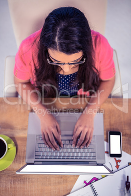 Overhead view of businesswoman typing on laptop keyboard