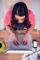Overhead view of businesswoman typing on laptop keyboard