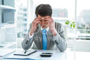 Troubled asian businessman in his desk