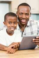 Father and son using tablet together