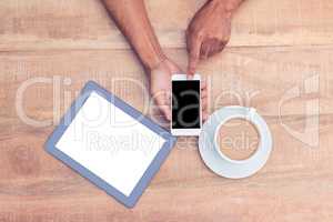 Person using smart phone by coffee and tablet