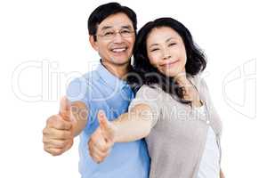 Couple standing together with thumbs up